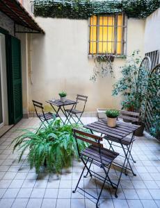 un patio con 2 mesas, sillas y plantas en Duomo street, en Nápoles