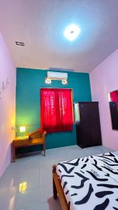 1 dormitorio con 1 cama y pared roja y verde en Twentynine Homestay en Banyuwangi