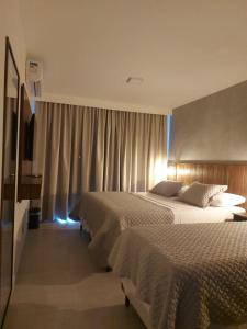 ein Hotelzimmer mit zwei Betten und einem Fernseher in der Unterkunft Pousada do Nica in Fernando de Noronha