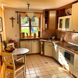 a kitchen with white cabinets and a table and a window at Ferienwohnung Kathi in Samerberg