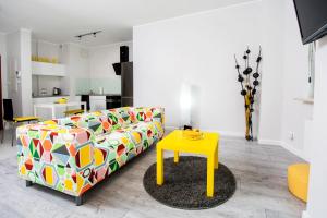 - un salon avec un canapé et une table jaune dans l'établissement Warsaw Night Apartments Giełdowa, à Varsovie