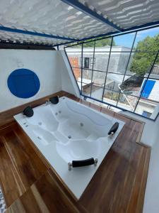 une baignoire jacuzzi dans une chambre avec fenêtres dans l'établissement Cabaña Santorini Doradal, à Doradal