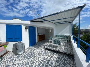 d'une terrasse avec des portes bleues et un banc. dans l'établissement Cabaña Santorini Doradal, à Doradal