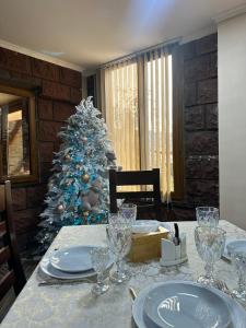 Un árbol de Navidad en un comedor con mesa en Colibri Hotel, en Haghpat