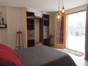 a bedroom with a bed and a sliding glass door at Chambre d'hôte dans chalet près des pistes et aux départs de randonnées in Les Carroz d'Araches