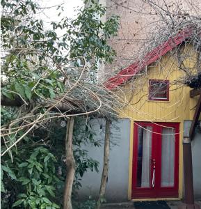 a house with a red door and a tree at Tiny house for 2 with private garden in Utrecht