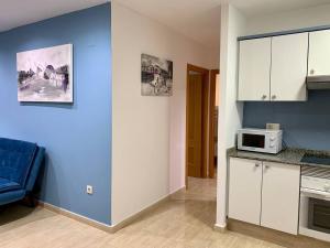 una cocina con armarios blancos y una pared azul en Experience Valencia Bnb - Rincon del Mar - Apartamento Maravilloso a Canet Playa 100 mt en Canet de Berenguer