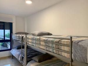 Tempat tidur susun dalam kamar di Experience Valencia Bnb - Rincon del Mar - Apartamento Maravilloso a Canet Playa 100 mt