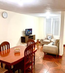 sala de estar con mesa, sofá y TV en Departamento completo a minutos de playas, en Barranca