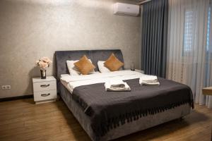 1 dormitorio con 1 cama grande y toallas. en Center Home Apartment, en Chişinău