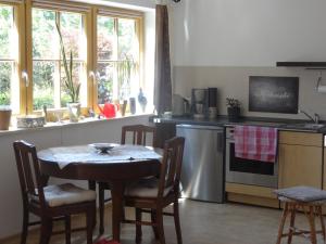 a kitchen with a table and a stove and a sink at Ferienwohnung Frühauf in Prien am Chiemsee