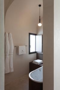 baño con bañera, lavabo y ventana en Palazzo Tafuri, en Nardò