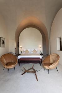1 dormitorio con 1 cama y 2 sillas en Palazzo Tafuri, en Nardò