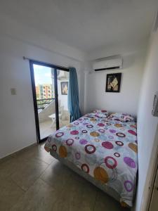 ein Schlafzimmer mit einem Bett und einem großen Fenster in der Unterkunft Arriendo Ciudad Flamingo in El Marite