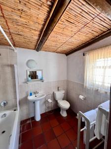 a bathroom with a toilet and a sink and a tub at Baywatch Paternoster - The Cottage in Paternoster
