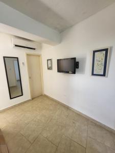 ein Wohnzimmer mit einem Flachbild-TV an der Wand in der Unterkunft Arriendo Ciudad Flamingo in El Marite