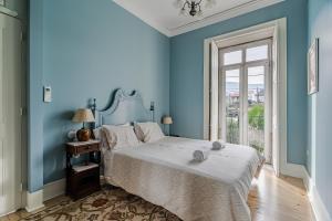 um quarto azul com uma cama e uma janela em Casa da Avó em Caminha