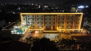un grande edificio con una piscina di fronte ad esso di notte di Hotel PVK Grand Dindigul a Dindigul
