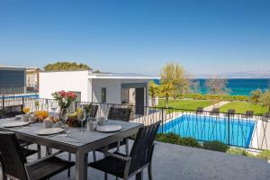 una mesa en un balcón con vistas a la piscina en HADRIE LUXURY RESORT AND VILLAS ROVA c, en Vantačići