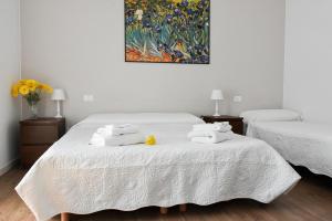 プレガンツィオールにあるB&B Ca' Rinaのベッドルーム1室(白いシーツと絵画が備わるベッド2台付)