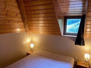 a bedroom with a white bed and a window at LES CHALETS D'AURE. in Aragnouet