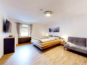 ein Schlafzimmer mit einem Bett und einem Sofa in der Unterkunft Ferienhaus Hennewinkl in Oetz