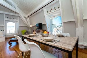 ein Esszimmer mit einem Holztisch und weißen Stühlen in der Unterkunft MY CASA - ETATS_UNIS 896 - OPERA -Magic view w/rooftop terrace in Nizza