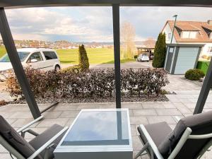 una mesa de cristal y sillas en un patio con coche en Stilvolles Apartment - mit E-Auto Lademöglichkeit, en Attendorn