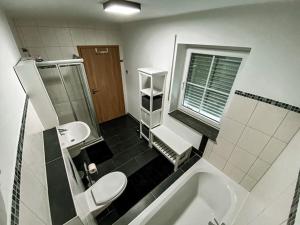 a bathroom with a toilet and a sink and a tub at Stilvolles Apartment - mit E-Auto Lademöglichkeit in Attendorn