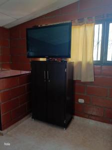 a flat screen tv sitting on top of a black cabinet at Cabañas La Honda in Guatapé