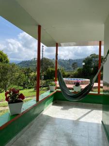 a hammock on the porch of a house at Macondo casa café in Salento