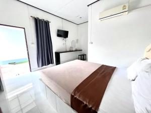 a bedroom with a bed and a large window at Rim Suan Resort in Satun