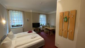 a bedroom with a bed and a dining room with a table at Pension Body Sun in Niesky