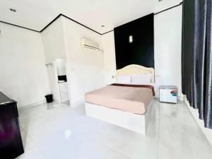 沙敦的住宿－Rim Suan Resort，一间白色的卧室,配有一张床和黑色的墙壁