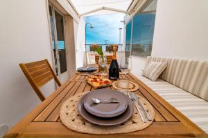 una mesa con un plato de comida y una botella de vino en Dimora del Vico - Exclusive Terrace with View, en Cisternino