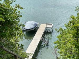 eine Anlegestelle mit einem Boot auf dem Wasser in der Unterkunft Newly reno Classic Lake Front Cottage with Dock in Sylvan Lake