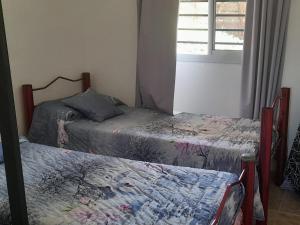two twin beds in a room with a window at ENCANTO SERRANO in Villa Carlos Paz