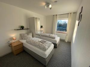Pokój z 2 łóżkami i oknem w obiekcie Ostfriesenfischer w mieście Leezdorf