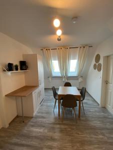 - une cuisine et une salle à manger avec une table et des chaises dans l'établissement Ostfriesenfischer, à Leezdorf