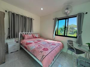 1 dormitorio con cama, escritorio y ventana en Pada Guesthouse Khaoyai, en Mu Si