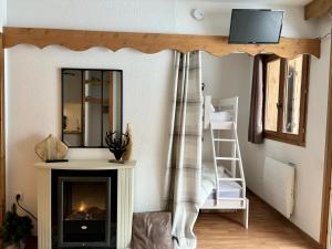 a living room with a fireplace and a mirror at Appartement chaleureux au ski avec piscine in Orelle