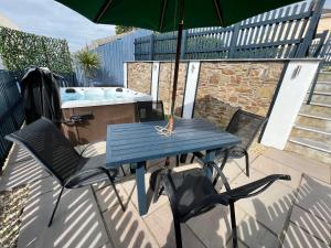 a table and chairs and an umbrella on a patio at Lundy SeaView Great Sea-views in Westward Ho