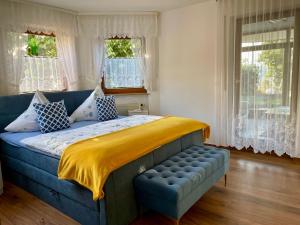 ein Schlafzimmer mit einem blauen Bett und einer gelben Decke in der Unterkunft Pension Höchemer in Bad Bocklet