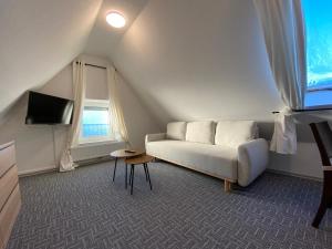 salon z białą kanapą i telewizorem w obiekcie Ostfriesenfischer w mieście Leezdorf