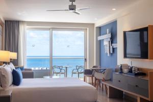 a hotel room with a bed and a view of the ocean at Royalton Splash Riviera Cancun, An Autograph Collection All-Inclusive Resort in Cancún