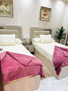 two beds sitting next to each other in a bedroom at شارع شومان من الاستاد in Tanta