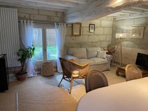 ein Wohnzimmer mit einem Sofa und ein Wohnzimmer mit einem Sofa in der Unterkunft Chambres d hôtes avec Piscine et Spa La Folière Saumur in Villebernier