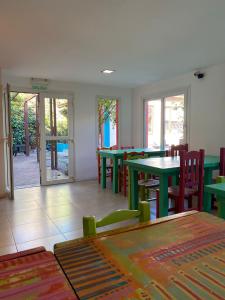 een eetkamer met groene tafels en stoelen en een patio bij Hostel Che Viajero in Villa Gesell +22 foto's