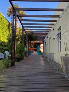een loopbrug naar een gebouw met een dak bij Hostel Che Viajero in Villa Gesell