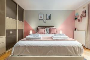 a bedroom with a large bed with pink walls at SUITE ET CHAMBRES COSY CHEZ A&M -ELEGANT HOME, CALME, CAMPAGNE, PARKING gratuit in Épône